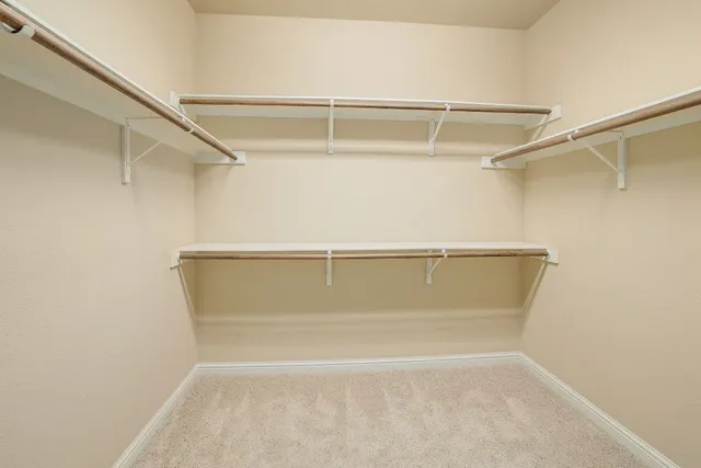 a view of walk in closet with empty racks