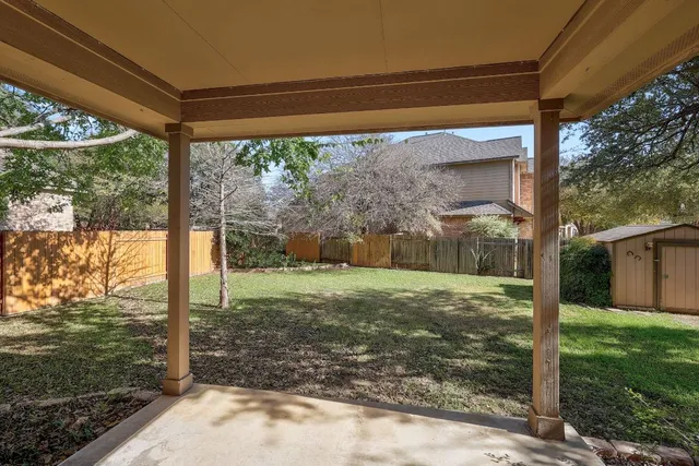 a view of a backyard with floor to ceiling window plants and trees