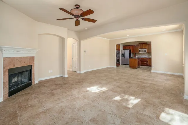 a view of a livingroom with a fireplace and a chandelier fan