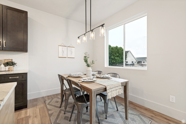 529 North Hvn Drive Mapleton, UT 84664 - Photo 13 of 30 Dining area featuring wood-finish flooring, a contemporary linear chandelier with clear glass shades, and a large window