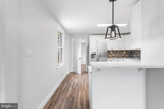 a view of hallway with chandelier and a wooden floor