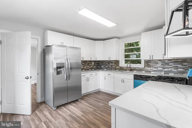 a kitchen with a refrigerator sink and cabinets