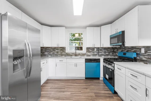 a kitchen with stainless steel appliances granite countertop a refrigerator sink and stove