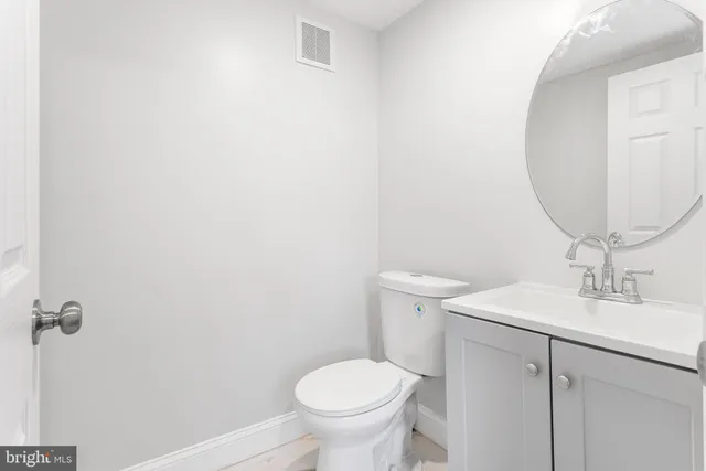 a bathroom with a toilet a sink and mirror