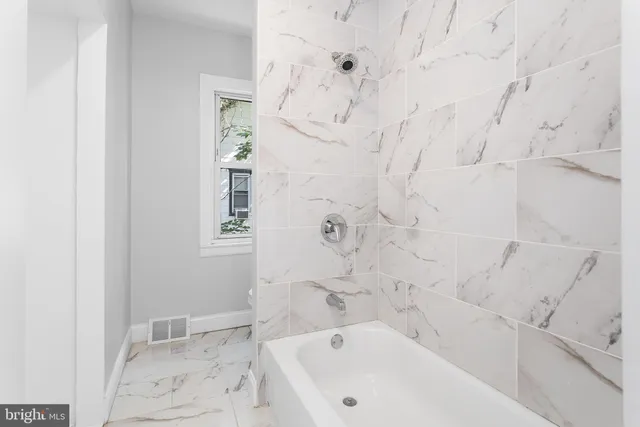 a bathroom with bathtub and shower