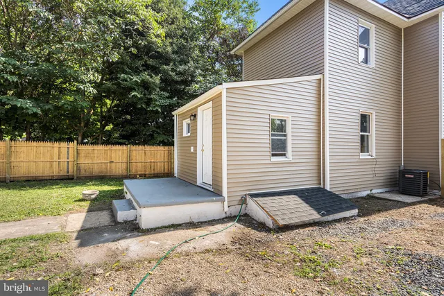 a view of backyard with wooden fence and trees