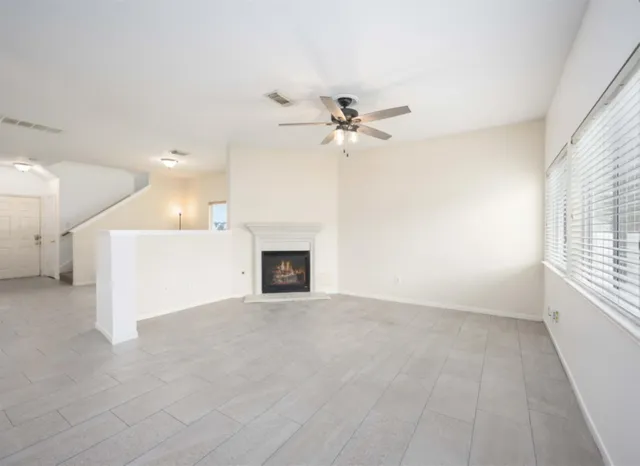 a view of an empty room with a fireplace and a window