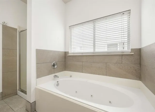 a white bath tub sitting in a bathroom next to a window