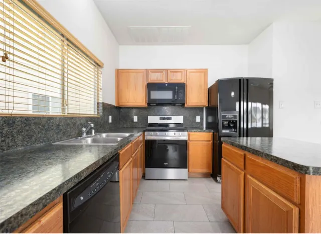 a kitchen with stainless steel appliances granite countertop a sink stove and refrigerator