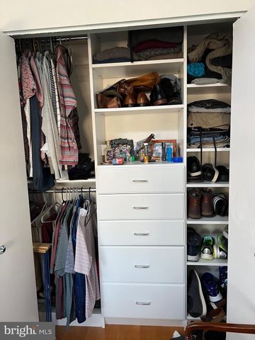 a view of walk in closet with clothes and shoes