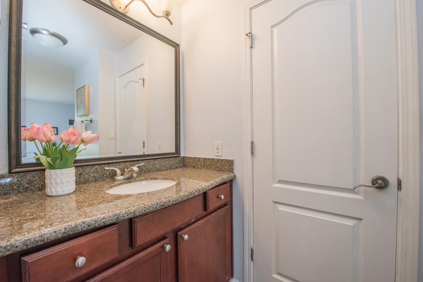 492 Dempsey Road, Unit 193 Milpitas, CA 95035 - Photo 9 of 35 a bathroom with a granite countertop sink and a mirror