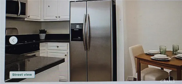 a kitchen with a refrigerator and a stove top oven