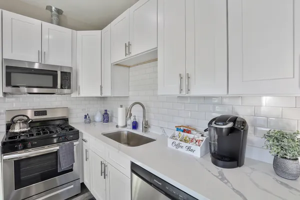 a kitchen with a sink a stove and cabinets