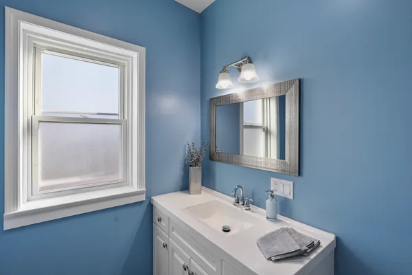 a bathroom with a sink vanity and mirror
