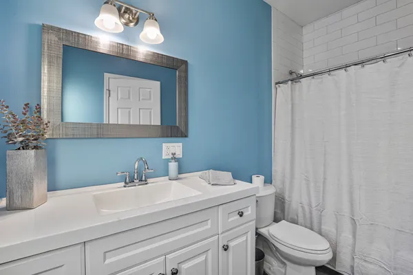 a bathroom with a sink a toilet and a mirror