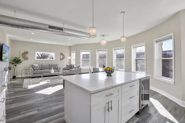 a open kitchen with stainless steel appliances granite countertop a lot of counter space and a living room