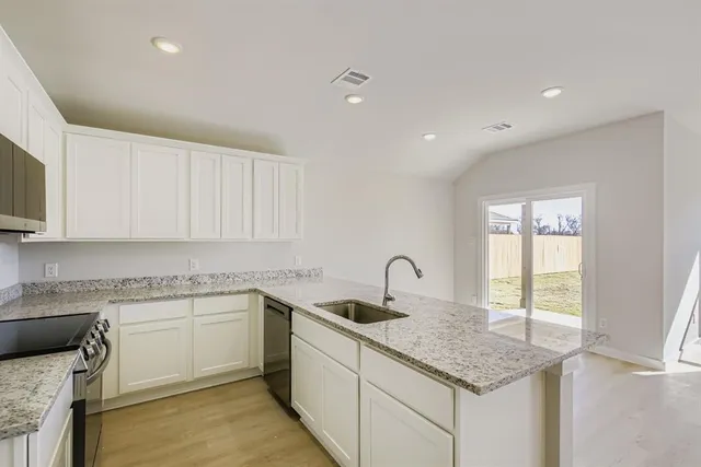 a kitchen with a sink stove and cabinets