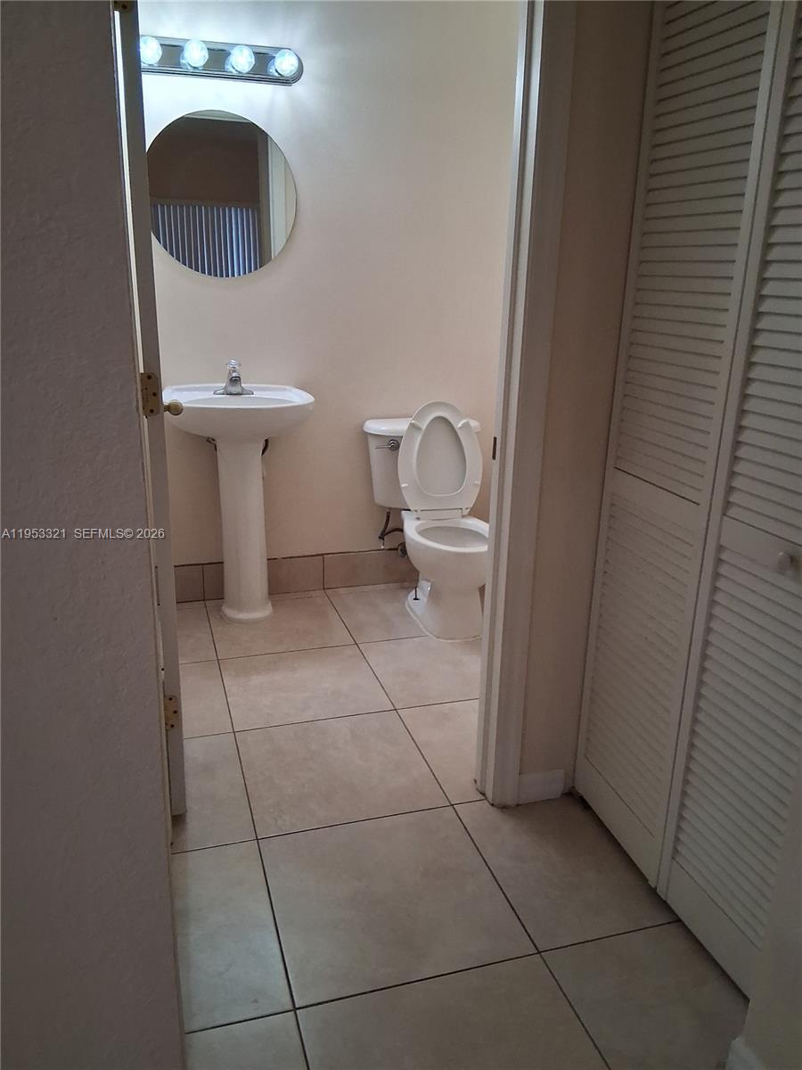 3395 Merrick Court, Unit 1110 Margate, FL 33063 - Photo 5 of 16 a bathroom with a sink a toilet and a mirror