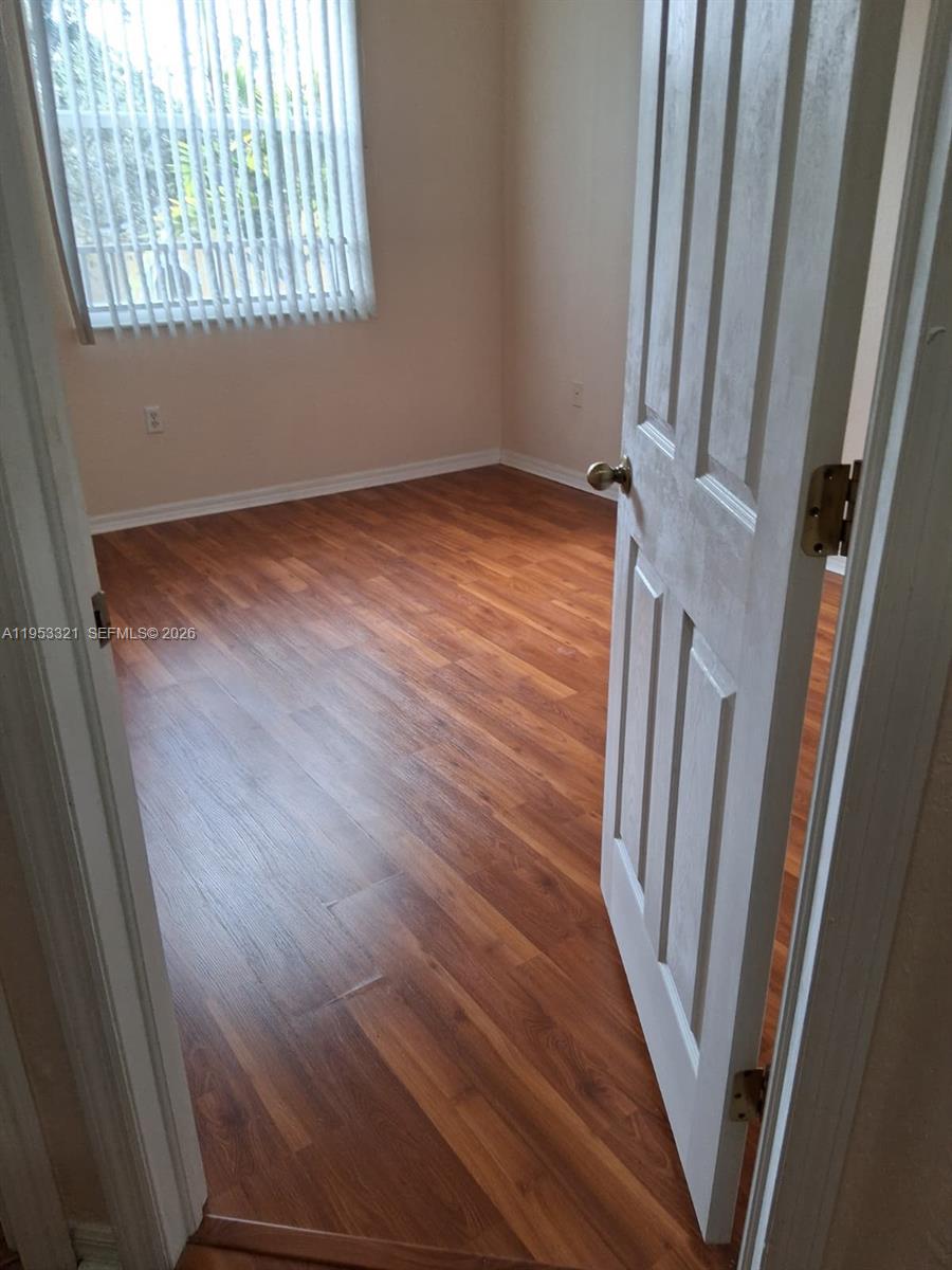 3395 Merrick Court, Unit 1110 Margate, FL 33063 - Photo 10 of 16 a view of an empty room with wooden floor and a window