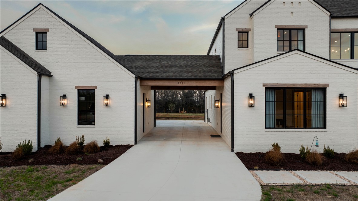 2811 Lebanon Road Pendleton, SC 29670 - Photo 8 of 50 This residence features a striking white brick exterior, Modern Brick, black-framed windows, and an inviting Porte Cochere entry.
