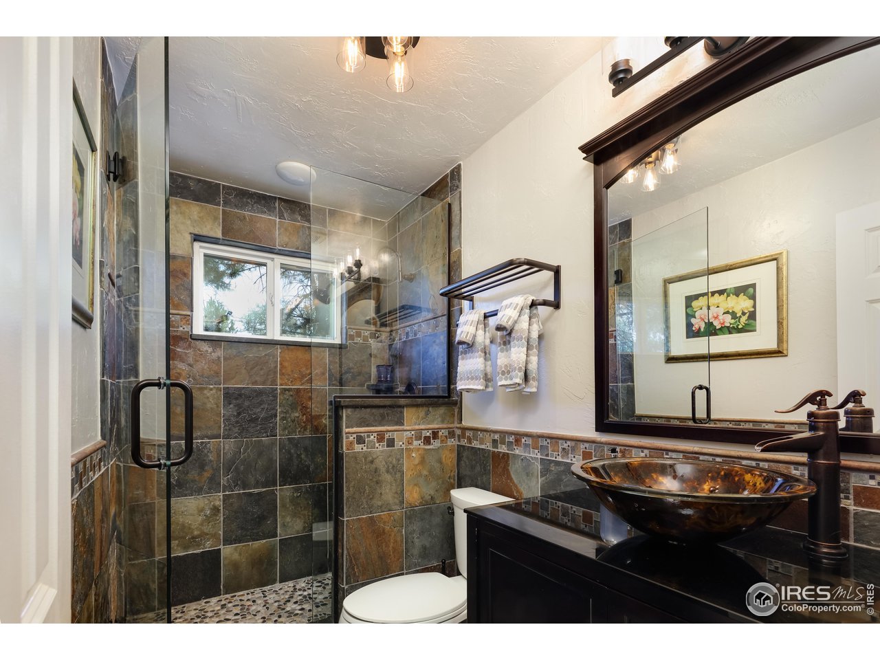 5825 Rustic Knolls Drive Boulder, CO 80301 - Photo 16 of 40 a bathroom with a sink mirror and a shower