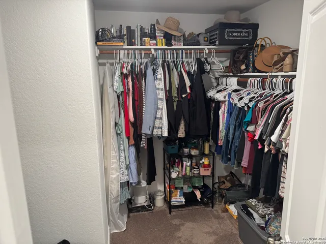 a view of walk in closet with clothes