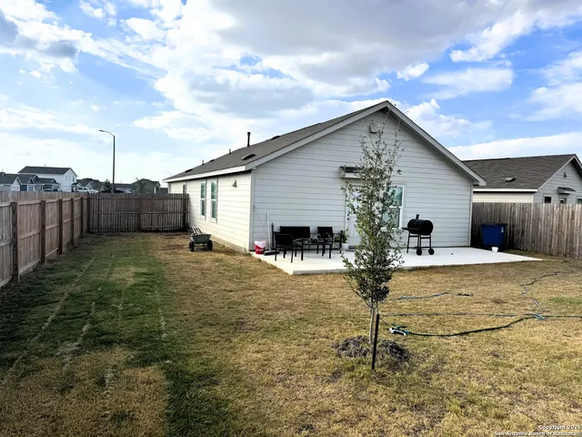 a view of a house with backyard and a tree