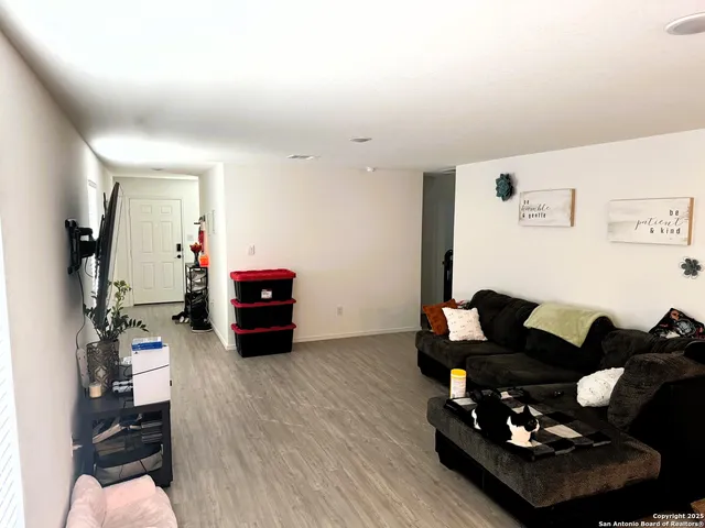 a living room with furniture and wooden floor