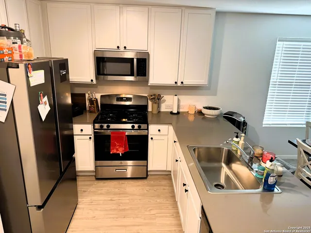 a kitchen with stainless steel appliances a stove microwave and a sink