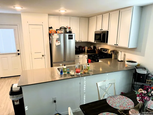 a kitchen with stainless steel appliances a refrigerator sink and microwave