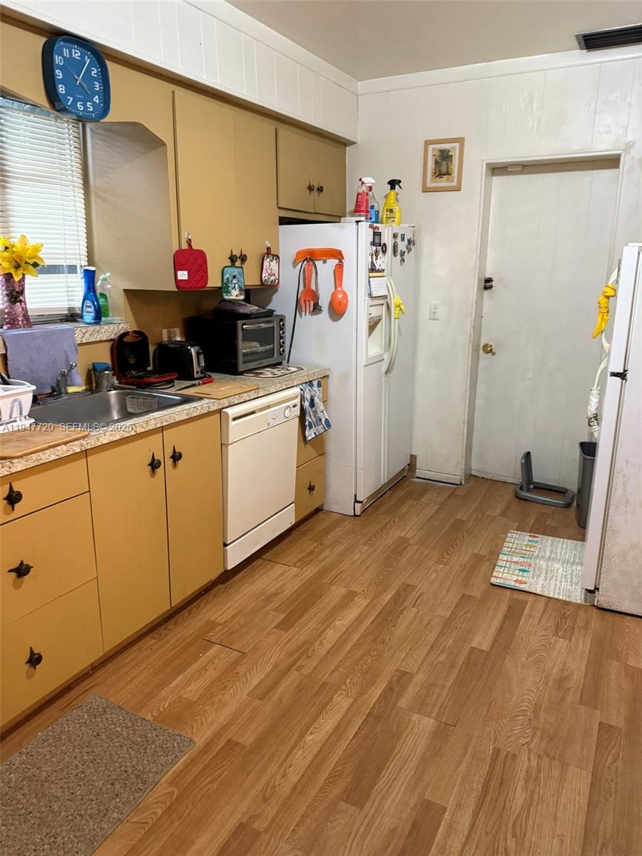 2560 Southwest 22nd Avenue Miami, FL 33133 - Photo 3 of 15 a view of a kitchen with fridge and wooden floor