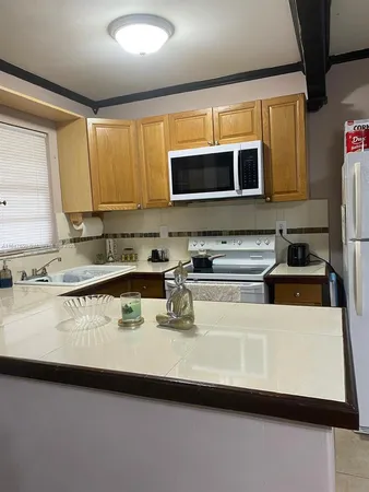 a kitchen with stainless steel appliances a sink a stove top oven a counter space and cabinets