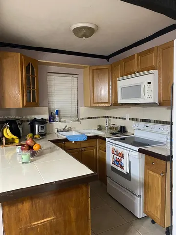 a kitchen with a sink a stove and cabinets