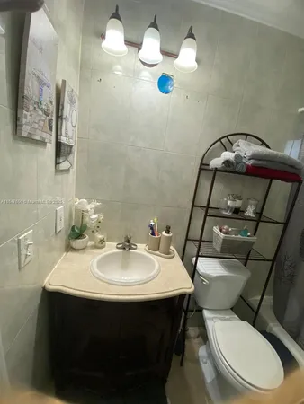 a bathroom with a sink mirror and toilet