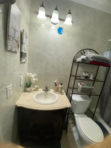 a bathroom with a sink mirror and toilet