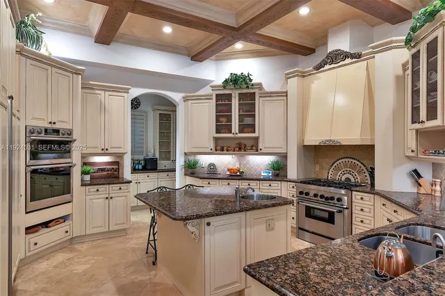 a kitchen with granite countertop a sink stainless steel appliances and cabinets