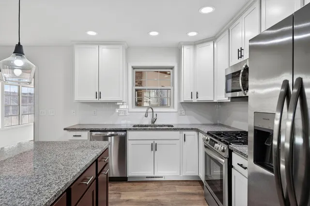 a kitchen with stainless steel appliances granite countertop a sink stove and refrigerator