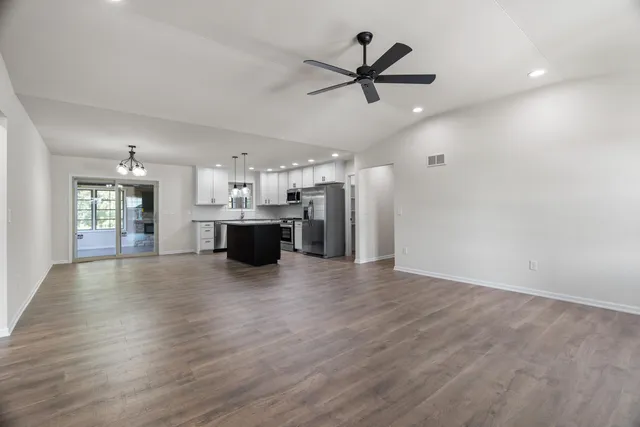 a view of a kitchen with a sink refrigerator and wooden floor
