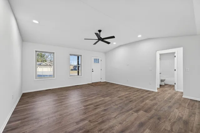 an empty room with fan and windows