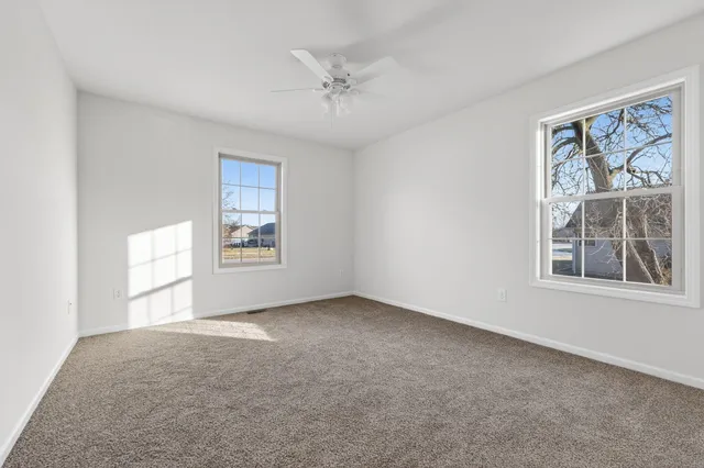 an empty room with windows and closet