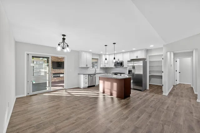 a large open kitchen with stainless steel appliances kitchen island a refrigerator sink and cabinets