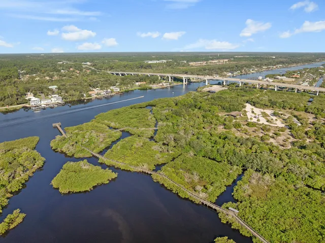 an aerial view of ocean and residential houses with outdoor space