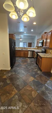 a kitchen with stainless steel appliances granite countertop a stove a sink and a refrigerator