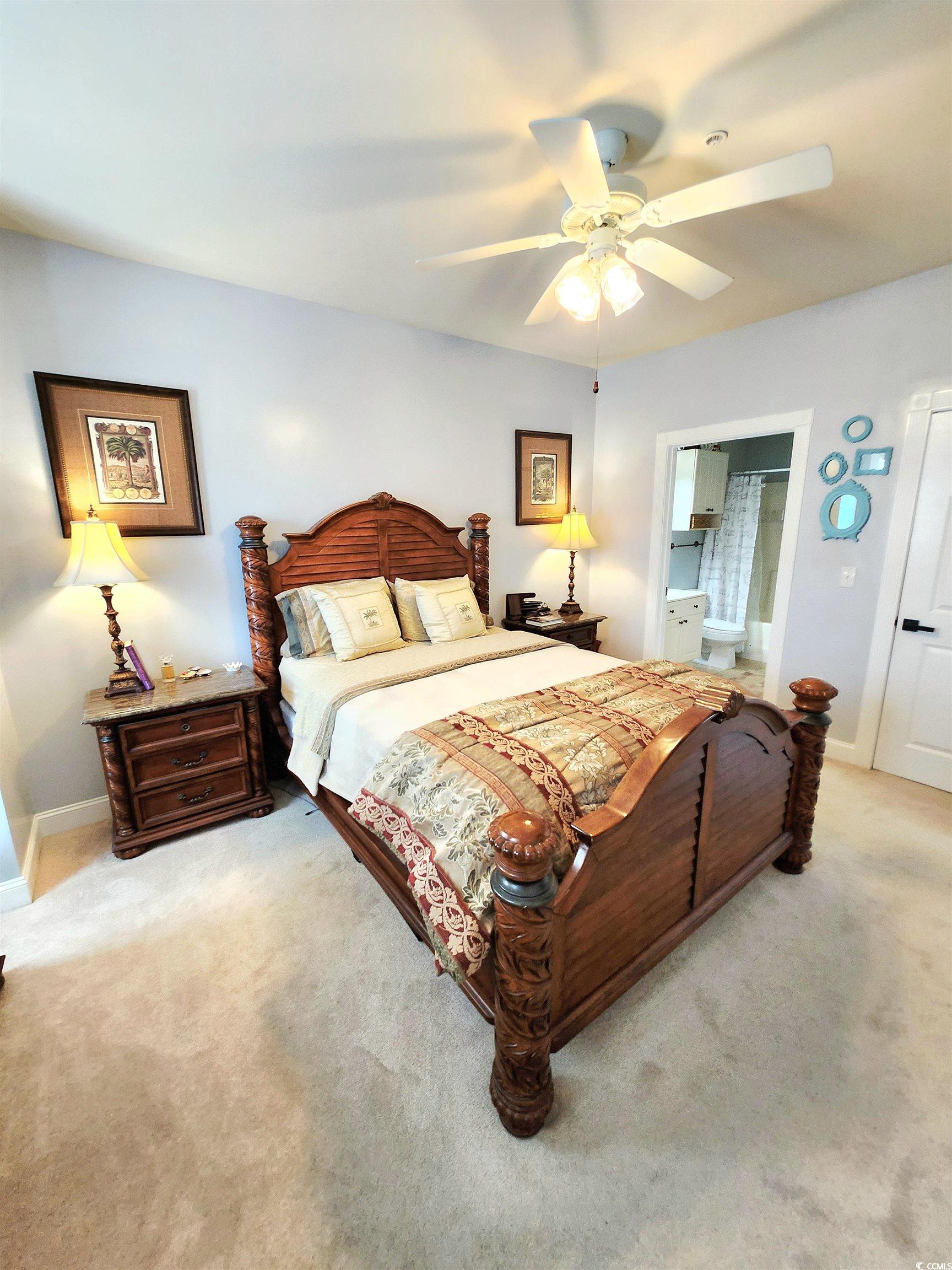 4877 Magnolia Pointe Lane, Unit 201 Myrtle Beach, SC 29577 - Photo 14 of 22 Bedroom featuring connected bathroom, a ceiling fan, and light carpet
