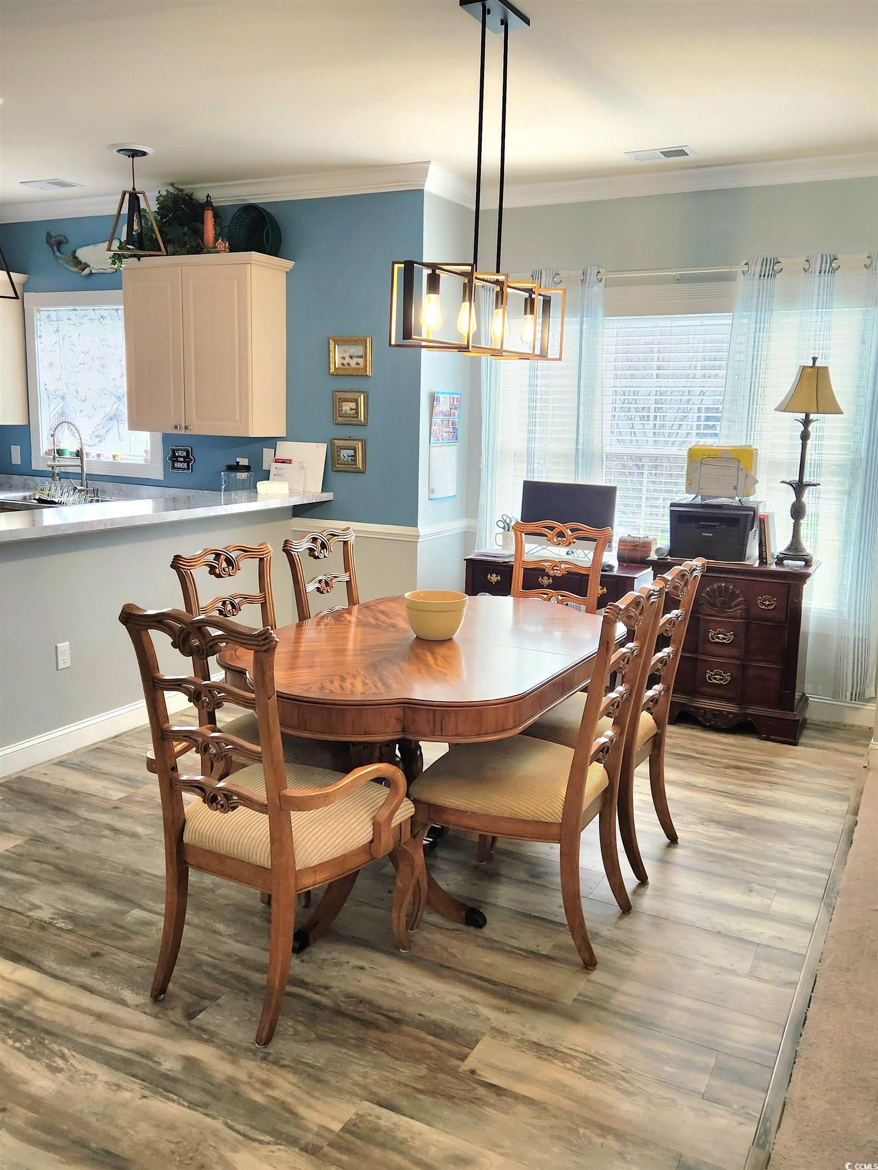 4877 Magnolia Pointe Lane, Unit 201 Myrtle Beach, SC 29577 - Photo 8 of 22 Dining room featuring crown molding and light wood-style flooring