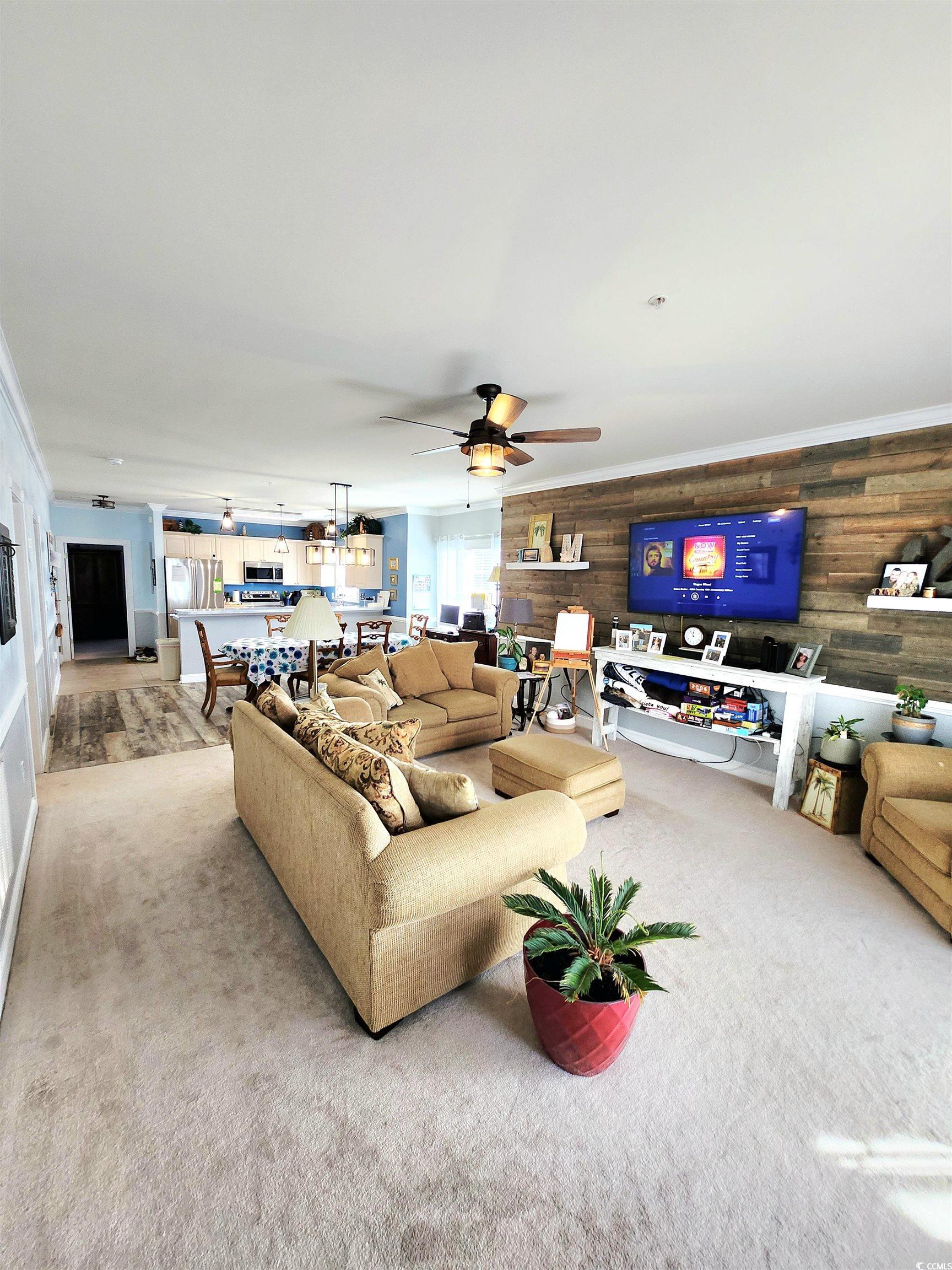 4877 Magnolia Pointe Lane, Unit 201 Myrtle Beach, SC 29577 - Photo 9 of 22 Living room featuring wooden walls, carpet, and ceiling fan