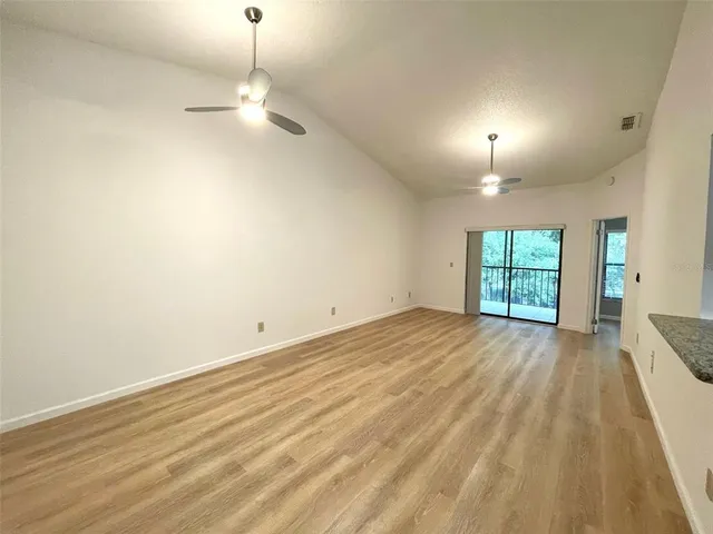 an empty room with window and wooden floor
