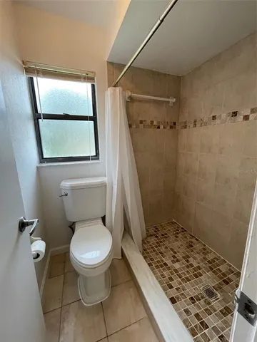 a bathroom with a toilet and a shower