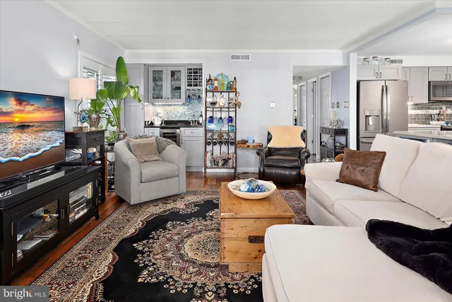 a living room with furniture a flat screen tv and kitchen view