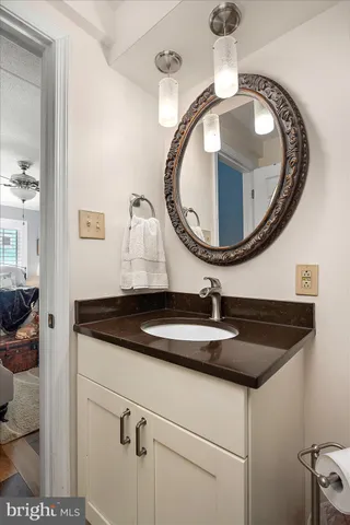 a bathroom with a granite countertop sink and mirror